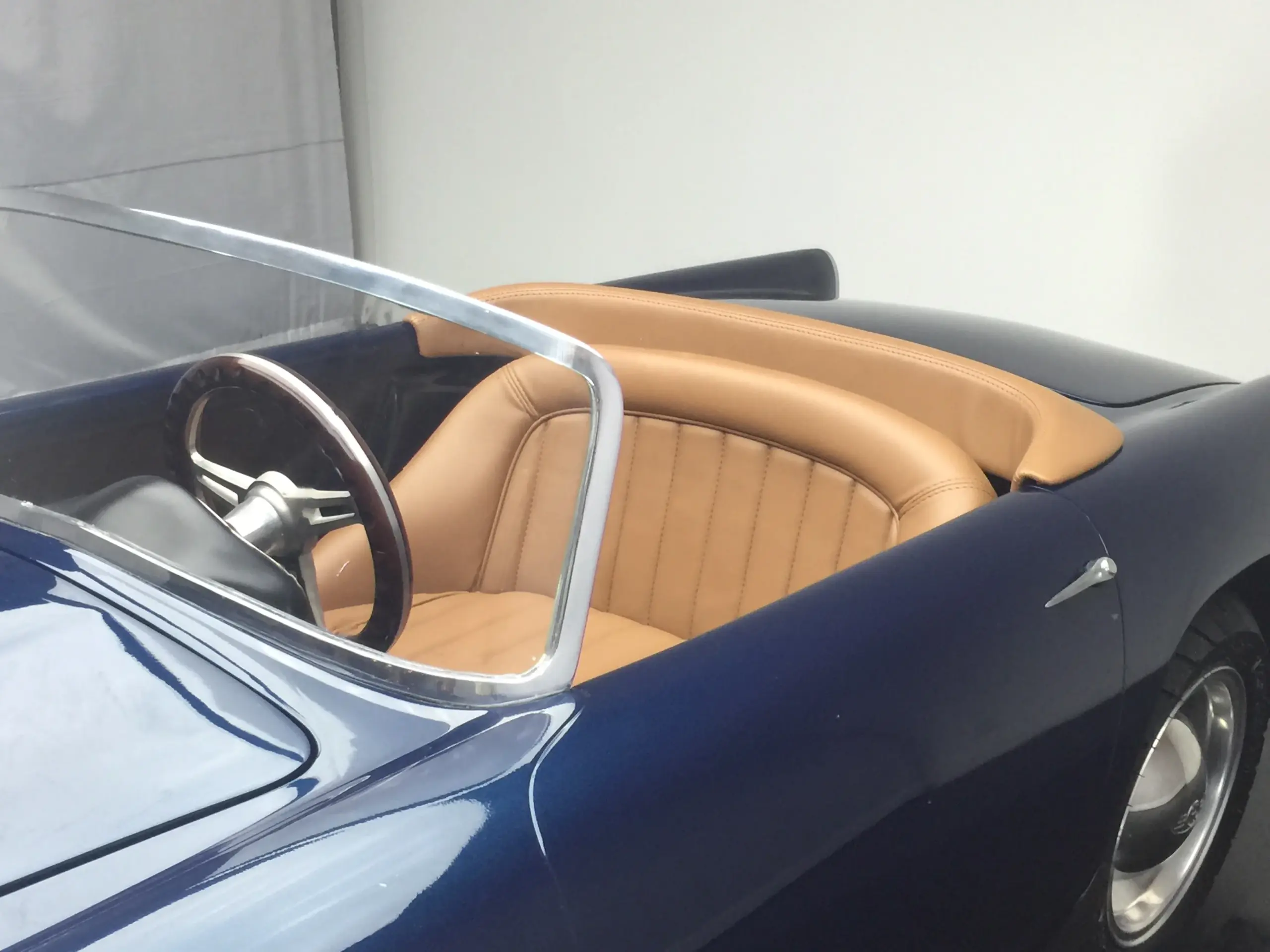 Innenraumaufnahme eines blauen GB Spirit Kinderfahrzeugs mit hellbraunem Ledersitz und sportlichem Lenkrad