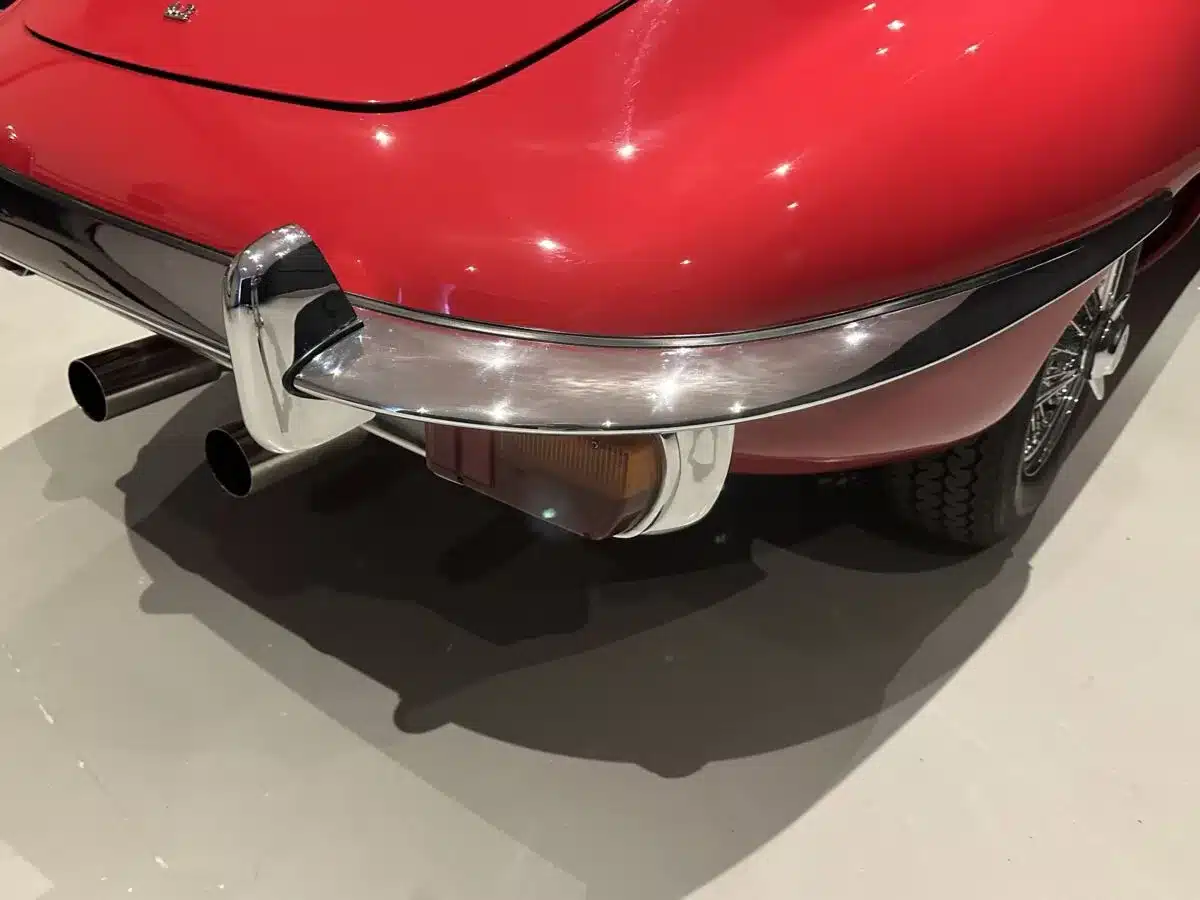 Nahaufnahme des Hecks eines roten Jaguar E-Type mit Chromstoßstange und Auspuff