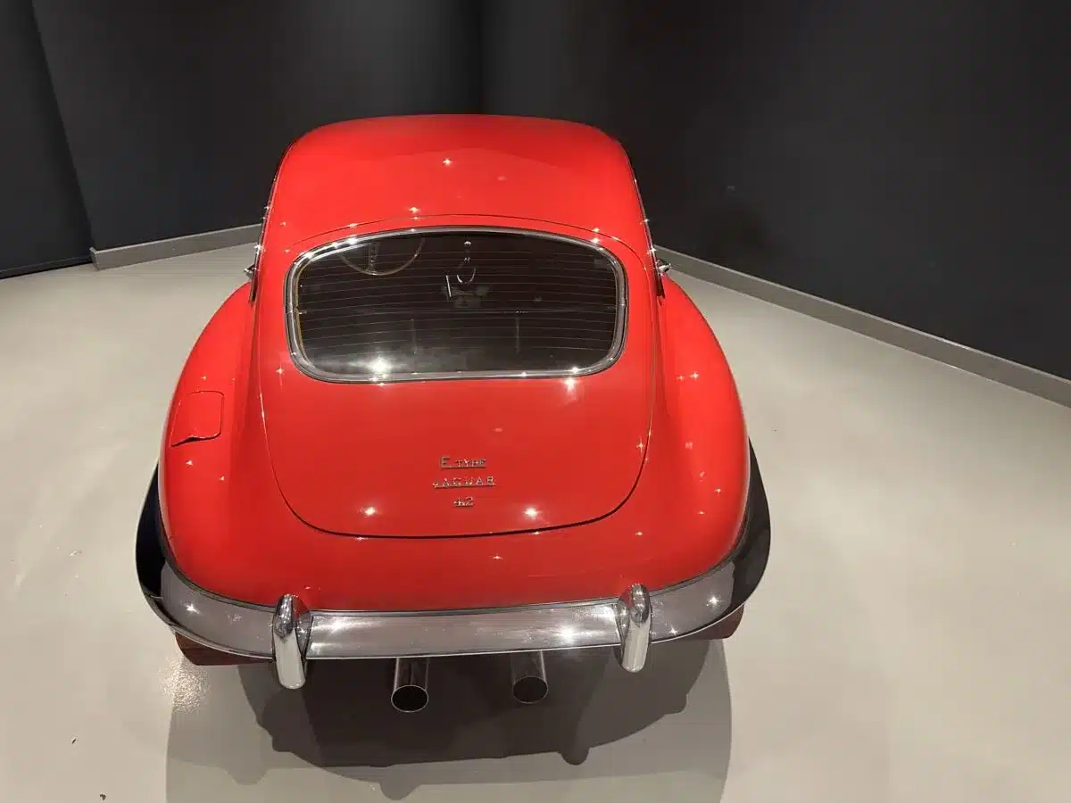 Heckansicht eines roten Jaguar E-Type Serie II Coupé mit typischer Linienführung und Jaguar-Emblem.