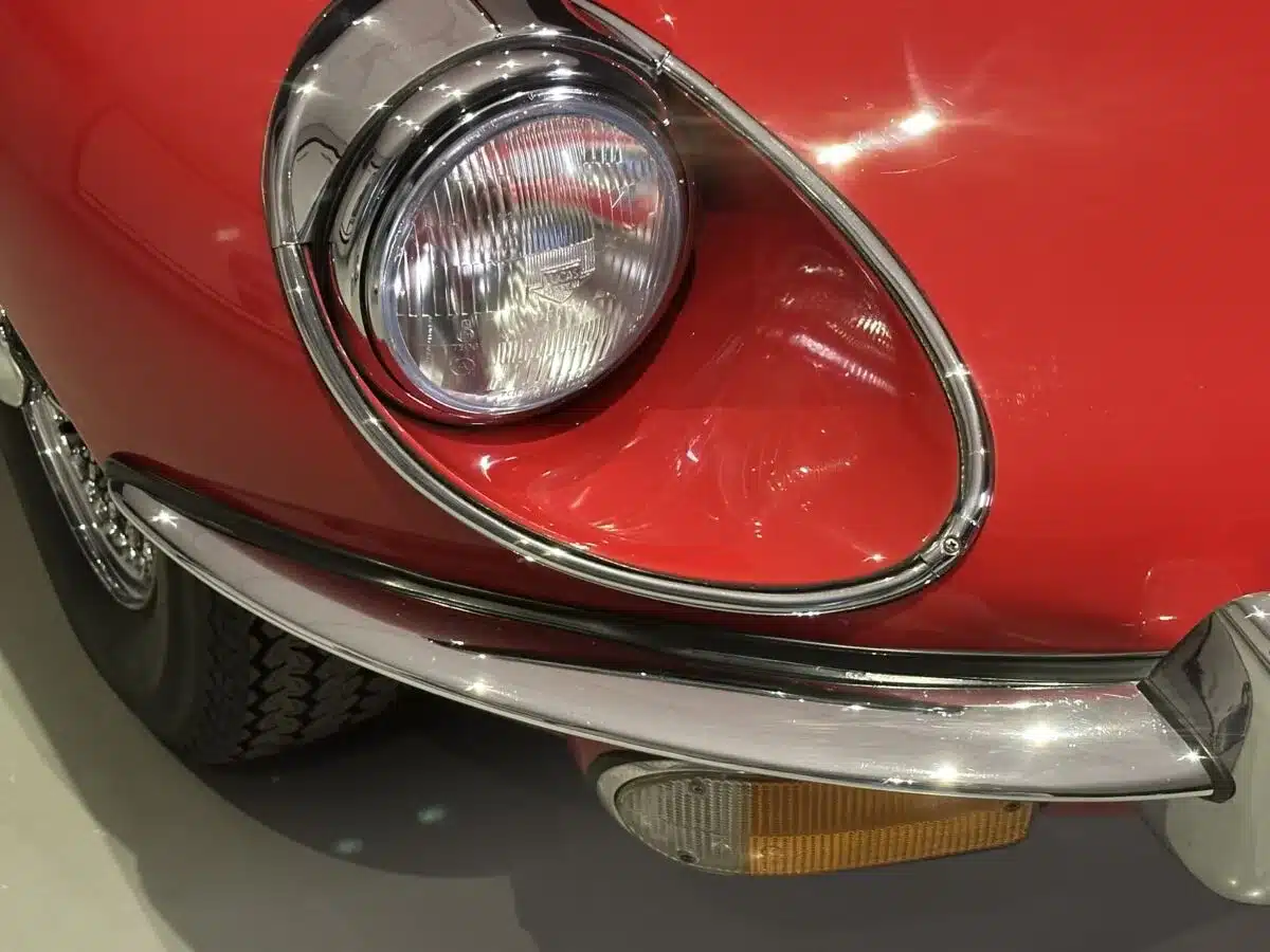 Nahaufnahme des Frontscheinwerfers und der Stoßstange eines roten Jaguar E-Type