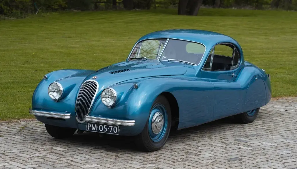 Blauer Jaguar XK 120 FHC 1951 als restauriertes Coupé-Oldtimerfahrzeug im Freien.