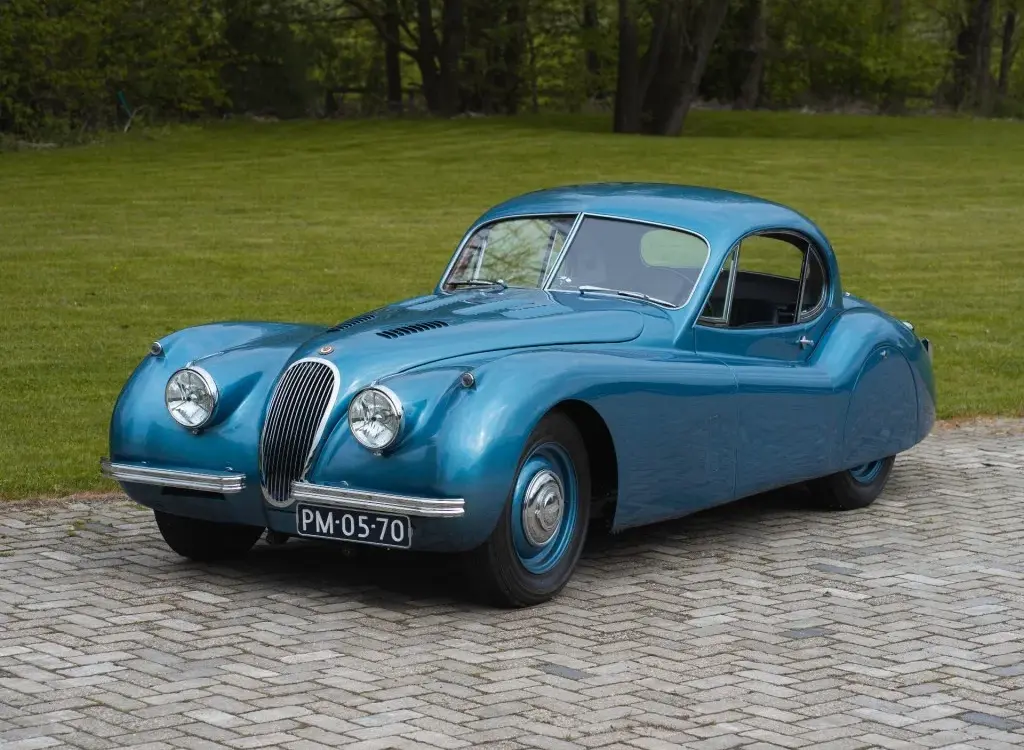 Blauer Jaguar XK 120 FHC 1951 als restauriertes Coupé-Oldtimerfahrzeug im Freien.