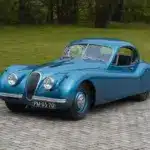 Blauer Jaguar XK 120 FHC 1951 als restauriertes Coupé-Oldtimerfahrzeug im Freien.