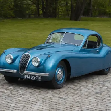 Blauer Jaguar XK 120 FHC 1951 als restauriertes Coupé-Oldtimerfahrzeug im Freien.