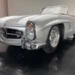 Silberfarbenes Junior-Car Silver Arrow 300 im Design eines klassischen Sportwagens mit offenem Cockpit und Chromdetails.