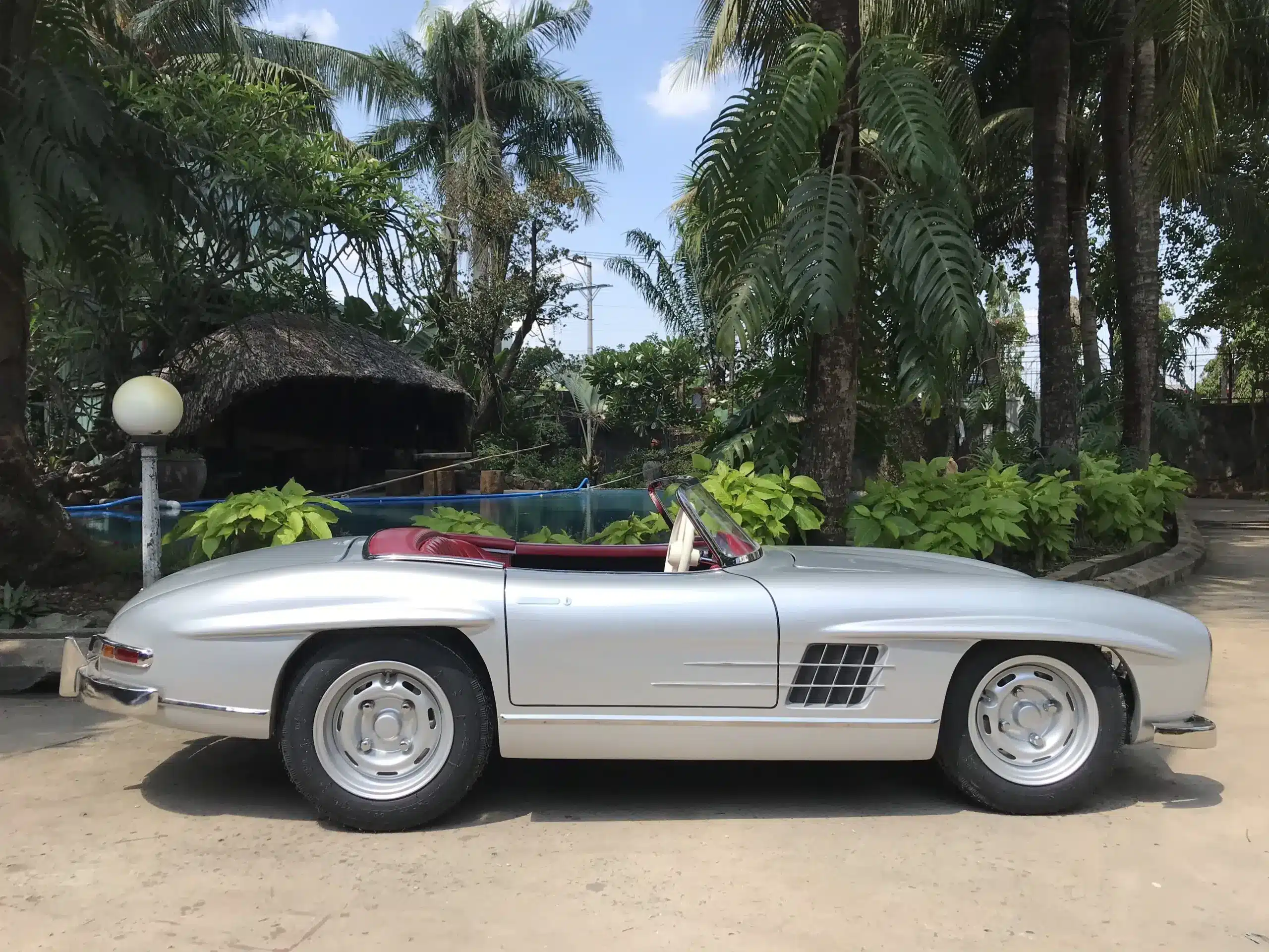 Silbernes Junior-Car im Stil klassischer Rennwagen mit offenem Cockpit, Einzelsitz und sportlichen Proportionen.