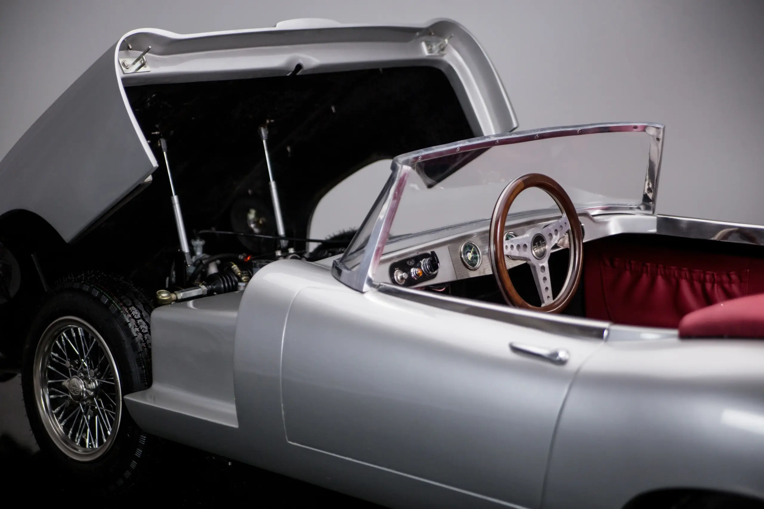 Junior Series 1: Innenraum mit Holzlenkrad, geöffnetem Vorderwagen und roten Ledersitzen