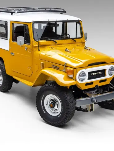 Restaurierter gelb-weißer Toyota Land Cruiser vor neutralem Hintergrund