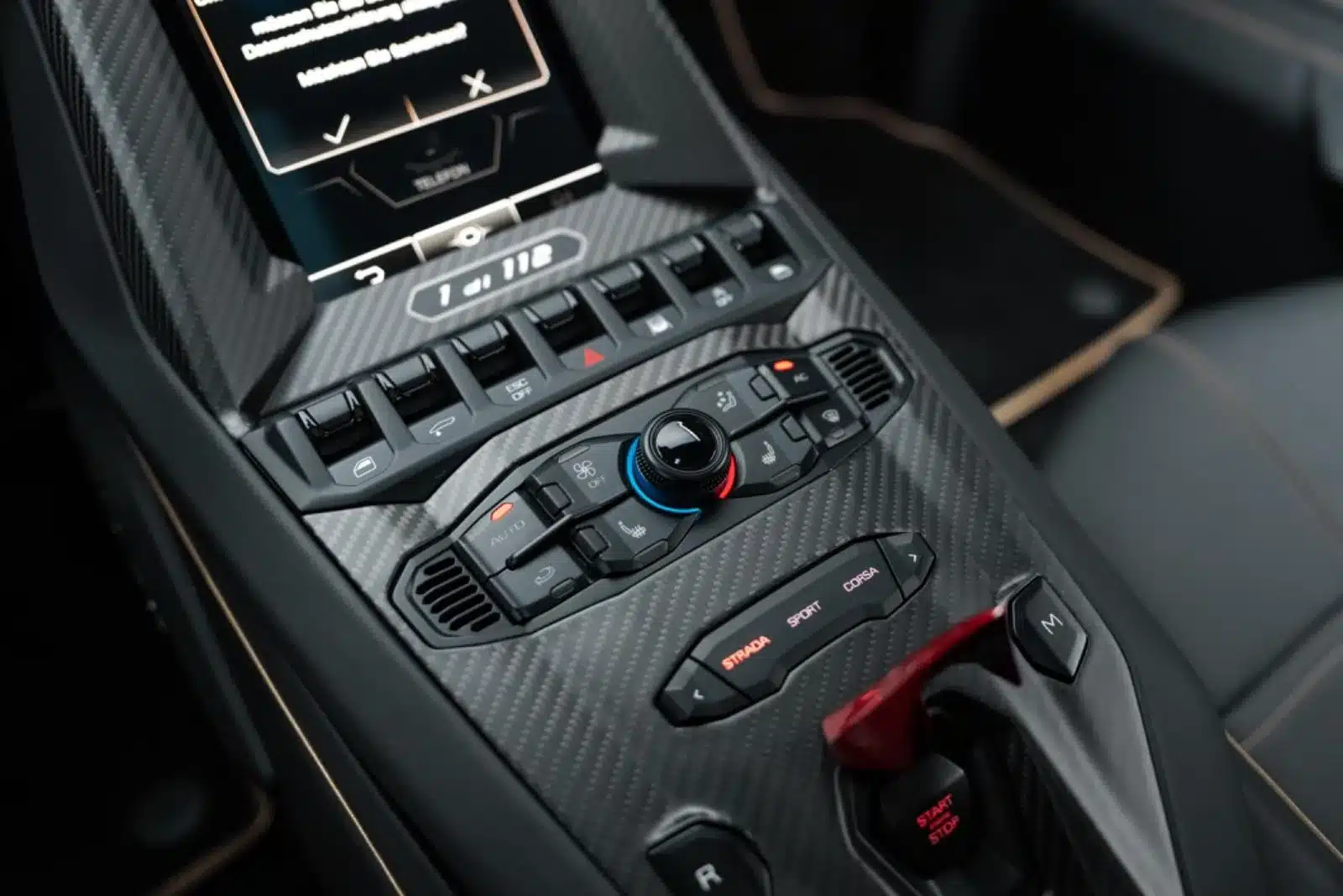 Nahaufnahme der Mittelkonsole im Lamborghini Countach LPI 800-4 in Carbon-Optik mit Fahrmodus-Wahlschalter und Bedienelementen
