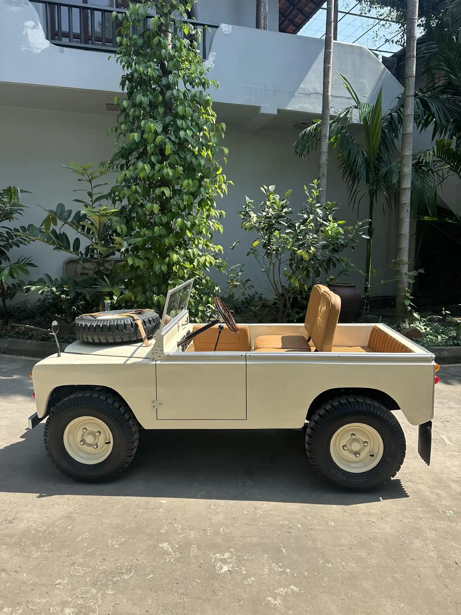 Das Kinderfahrzeug Land Junior im Stil klassischer Offroader, seitlich fotografiert und im Freien geparkt.