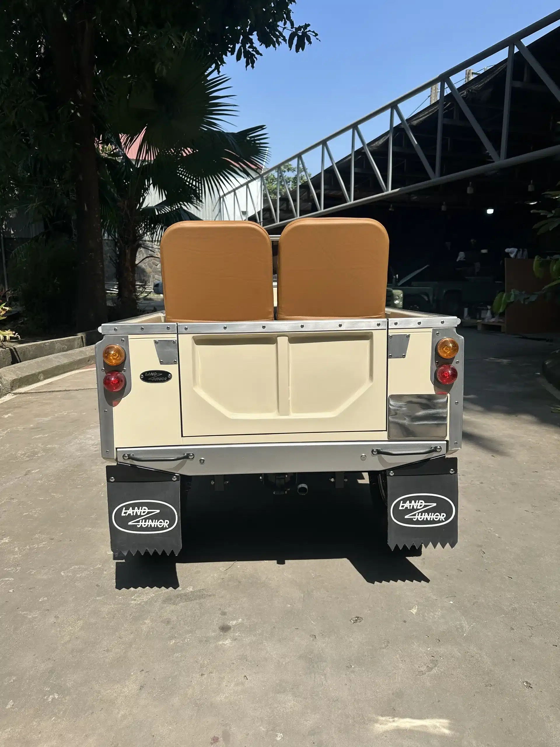 Land Junior Kinderfahrzeug von hinten mit zwei Sitzen und Markenschriftzug auf den Schmutzfängern.