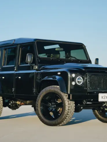 Schwarzer Land Rover Defender 110 300Tdi Baujahr 1998 mit LED-Scheinwerfern, 20-Zoll-Rädern und markanter Offroad-Optik im Freien.