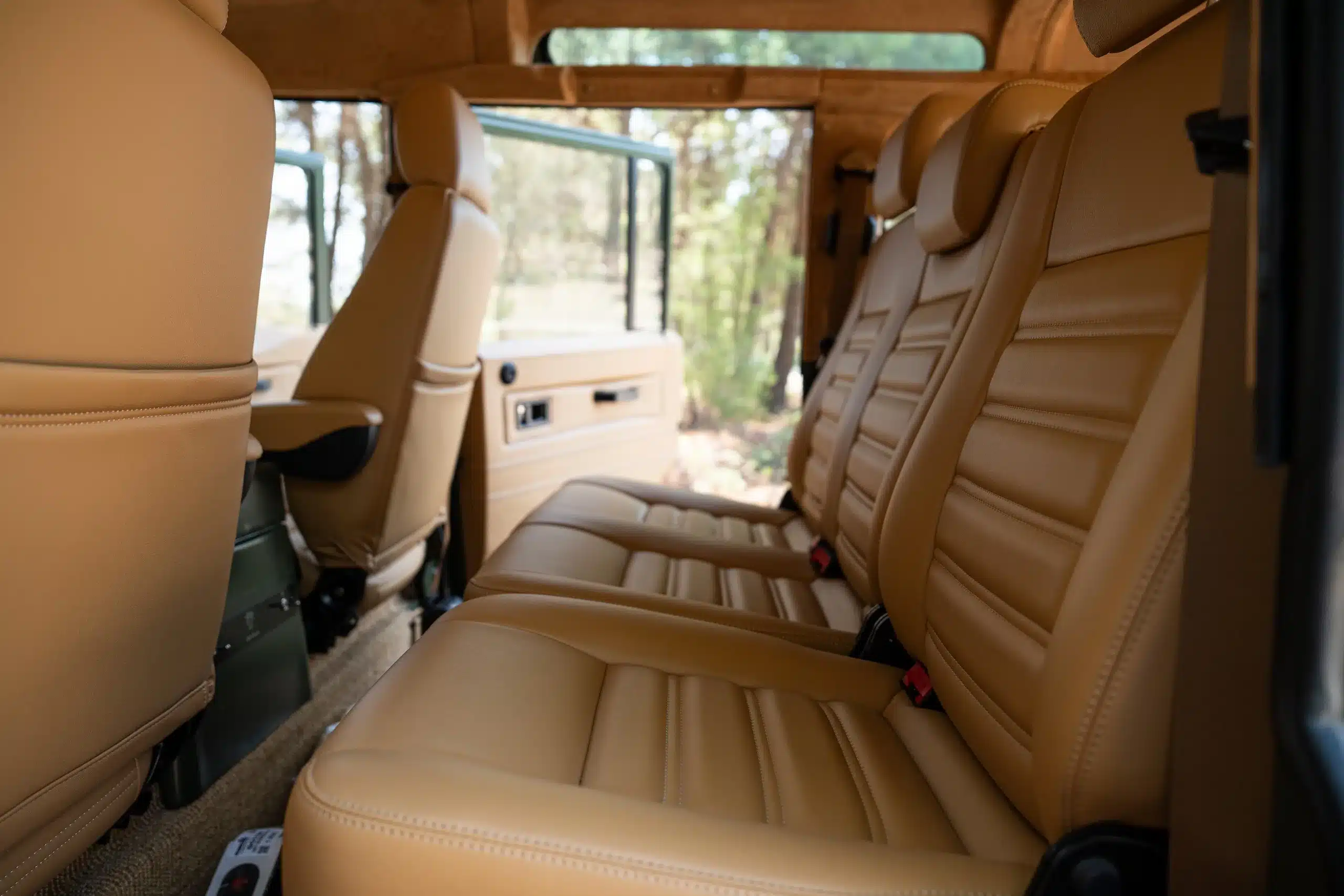 Innenraumansicht eines Land Rover Defender 110 (1999) mit hochwertig veredeltem, beigem Lederinterieur und großzügigem Sitzkomfort.