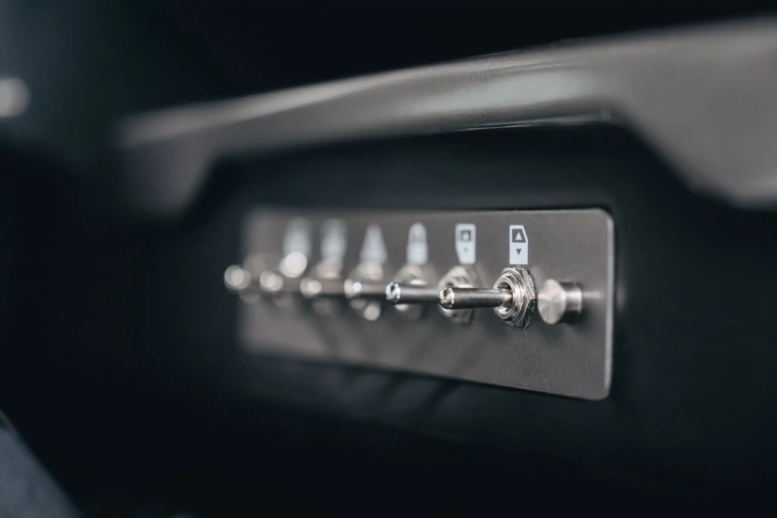 Metallschalter einer Schalterleiste im Innenraum eines Land Rover Defender 110, Detailaufnahme.