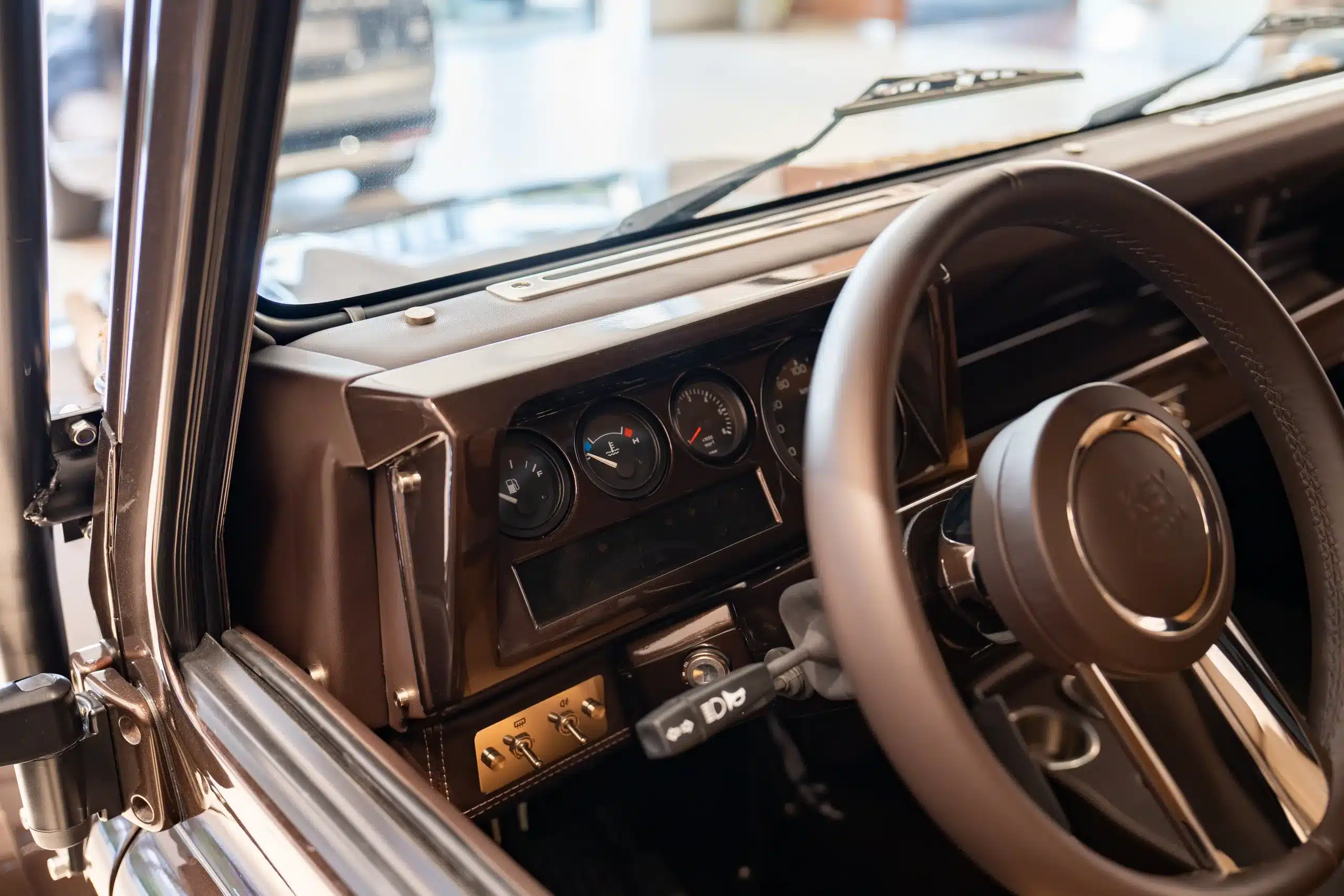 Armaturenbrett und Lenkrad eines braunen Land Rover Defender 110 von 1999