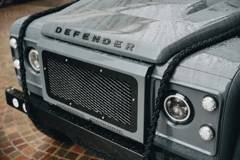Detailaufnahme der Front eines Land Rover Defender 110 mit Regenperlen auf der Motorhaube