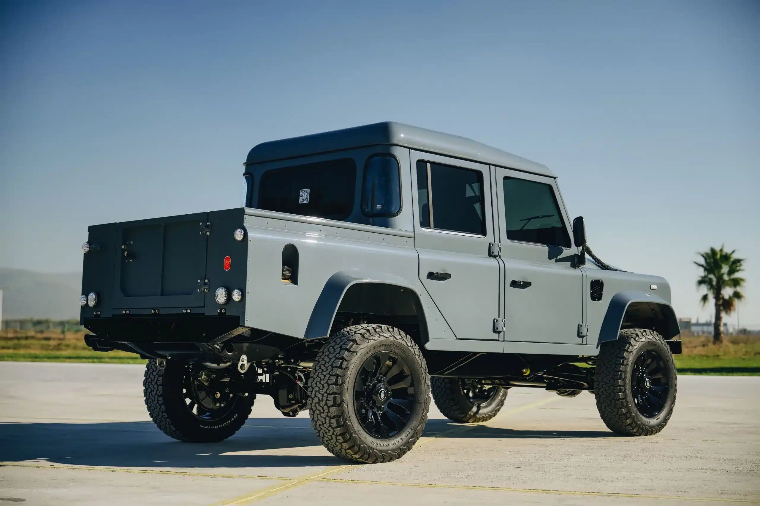 Seitenansicht eines grauen Land Rover Defender 110 mit Doppelkabine und Pick-up-Aufbau