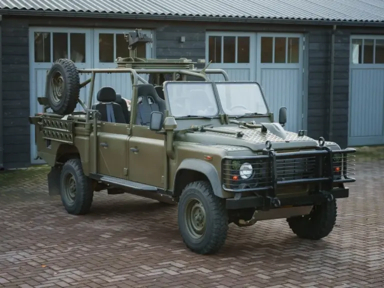 Land Rover Defender 130 WMIK 2013 ohne Türen und Dach in militärischer Ausführung vor Garage