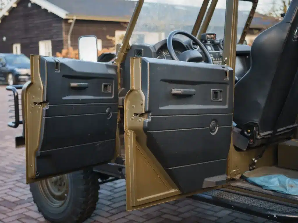 Geöffnete Türen eines Land Rover Defender 130 WMIK zeigen den Innenraum und das Lenkrad