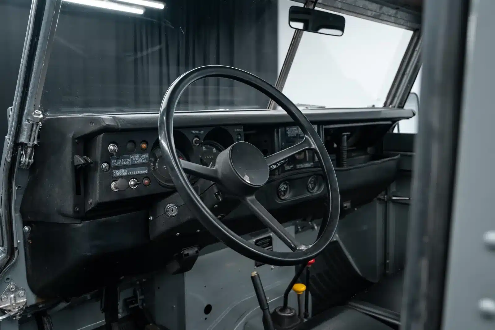 Lenkrad und Armaturenbrett eines Land Rover Serie III 109 LWB in Militär-Umbau, Innenaufnahme