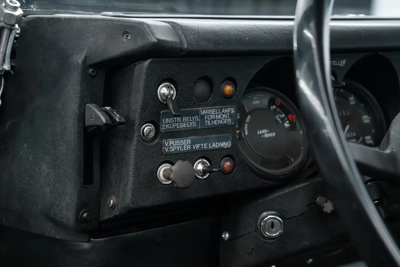 Detailansicht des Armaturenbretts mit Schaltern und Instrumenten im Land Rover Serie III 109 LWB Militärausführung