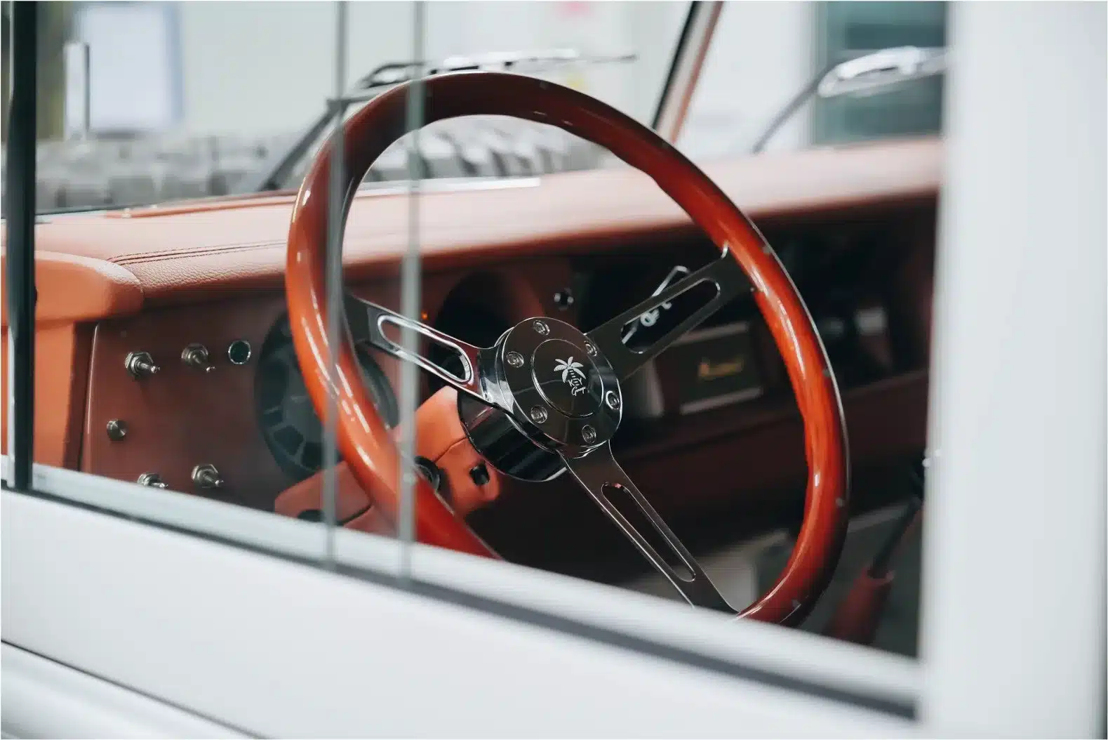 Innenraum eines Land Rover Series III von 1973 mit cremefarbenem Leder, elektrisch unterstütztem Holzlenkrad und klassischem Armaturenbrett