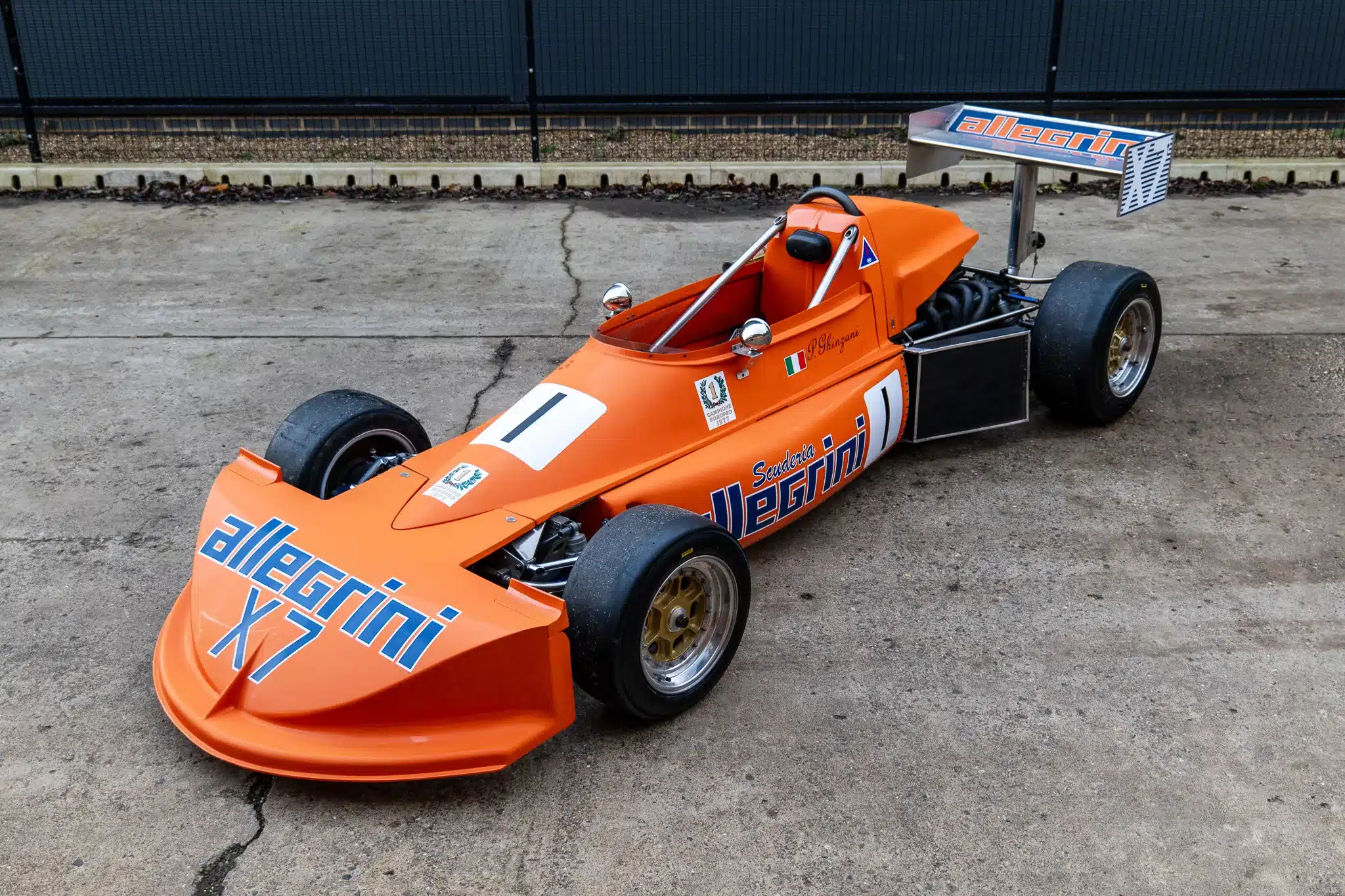 March 773 Formel-3-Rennwagen, Baujahr 1977, in orangefarbener Allegrini-Lackierung, von schräg vorne fotografiert.