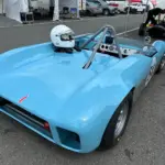 Rennwagen Merlyn Mk4A von 1964 in hellblau, geparkt im Fahrerlager mit aufgesetztem Helm