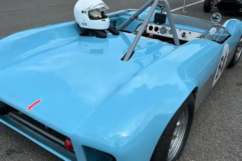 Rennwagen Merlyn Mk4A von 1964 in hellblau, geparkt im Fahrerlager mit aufgesetztem Helm