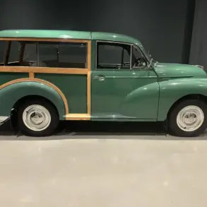 Grüner Morris Minor 1000 Traveller von 1964 mit sichtbarem Holzrahmen, im Ausstellungsraum seitlich fotografiert