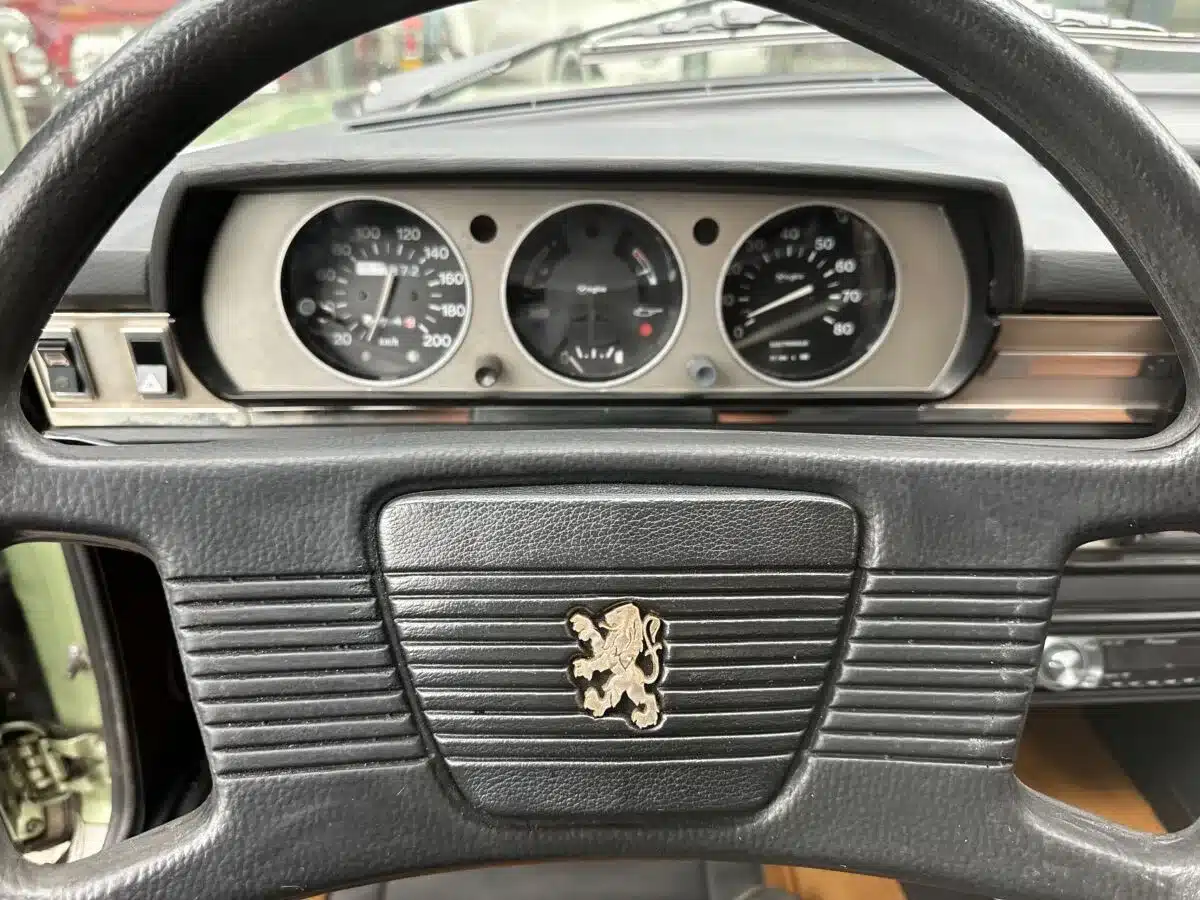 Nahaufnahme vom Lenkrad und den Instrumenten eines Peugeot 504 Ti.
