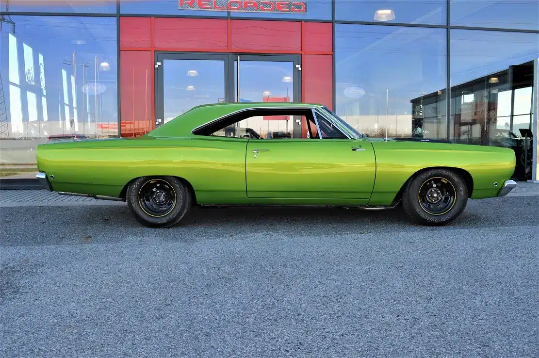 Grüner Plymouth Road Runner 383, Baujahr 1968, vor einem modernen Gebäude