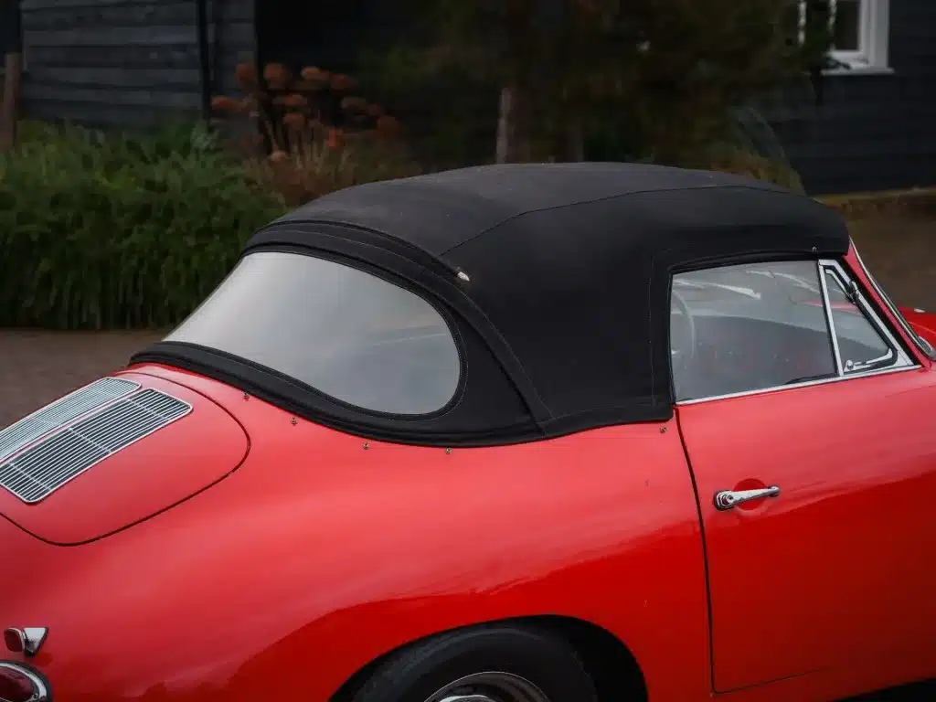 Rotes Porsche 356 C Cabriolet von 1965 mit geschlossenem Stoffverdeck, Detailansicht der Karosserie und Fenster.