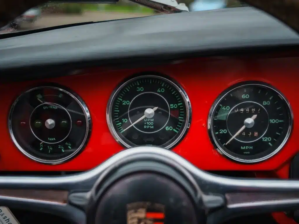 Tacho, Drehzahlmesser und Ölanzeige im roten Armaturenbrett eines Porsche 356 C Cabriolet von 1965, Blick durch das Lenkrad.