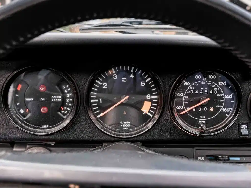 Tachometer und Instrumente im Armaturenbrett eines Porsche 911 3.2 Targa von 1984, mit sichtbarem Kilometerstand.