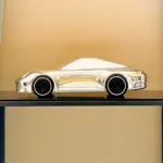 Aluminium-Skulptur eines Porsche 992 auf schwarzem Sockel mit hochglanzpolierter Oberfläche und schwarzen Felgen.