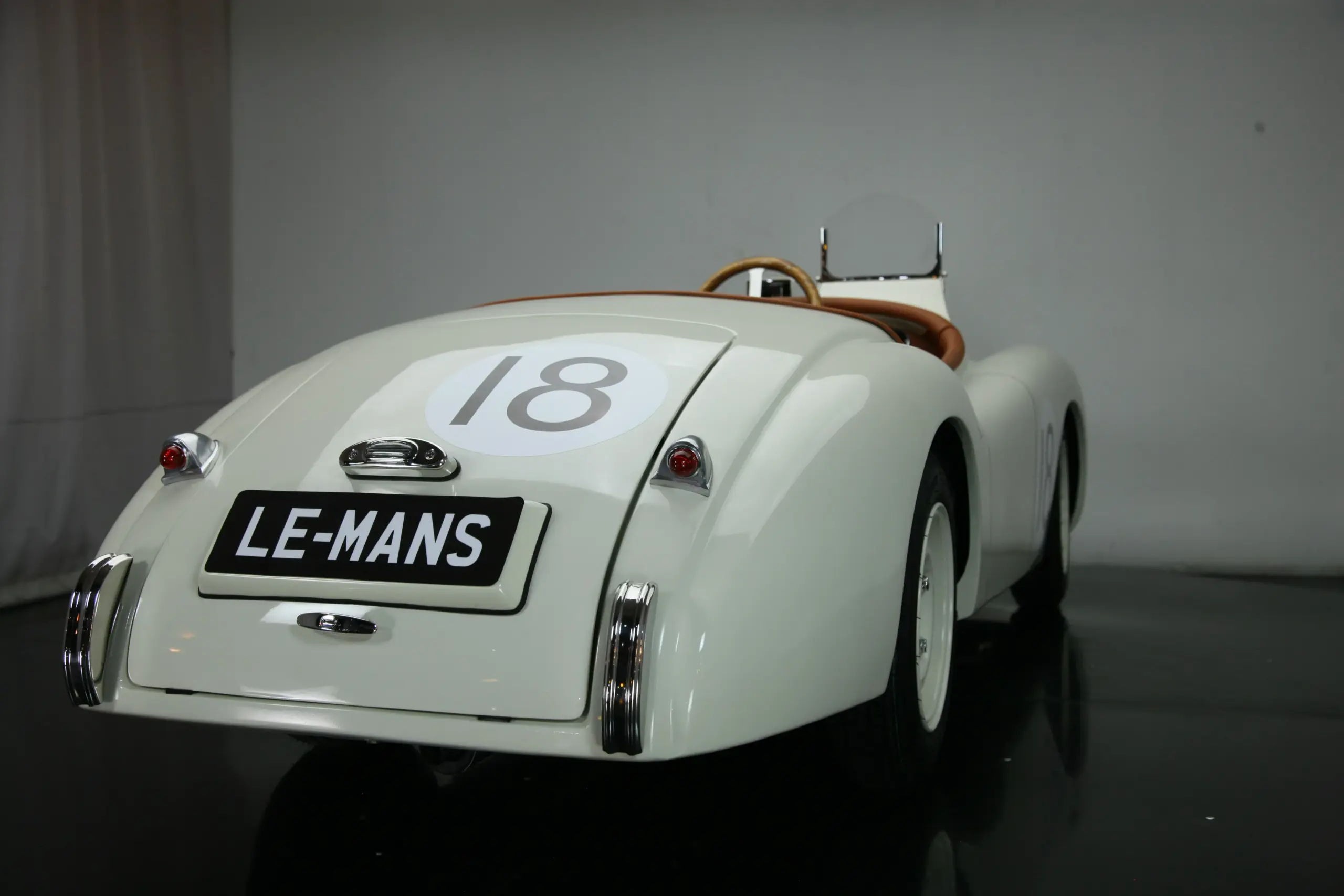 Miniatur-Replik eines weißen XK120 Roadster Red mit Startnummer 18 und Le-Mans-Kennzeichen, Ansicht von hinten.