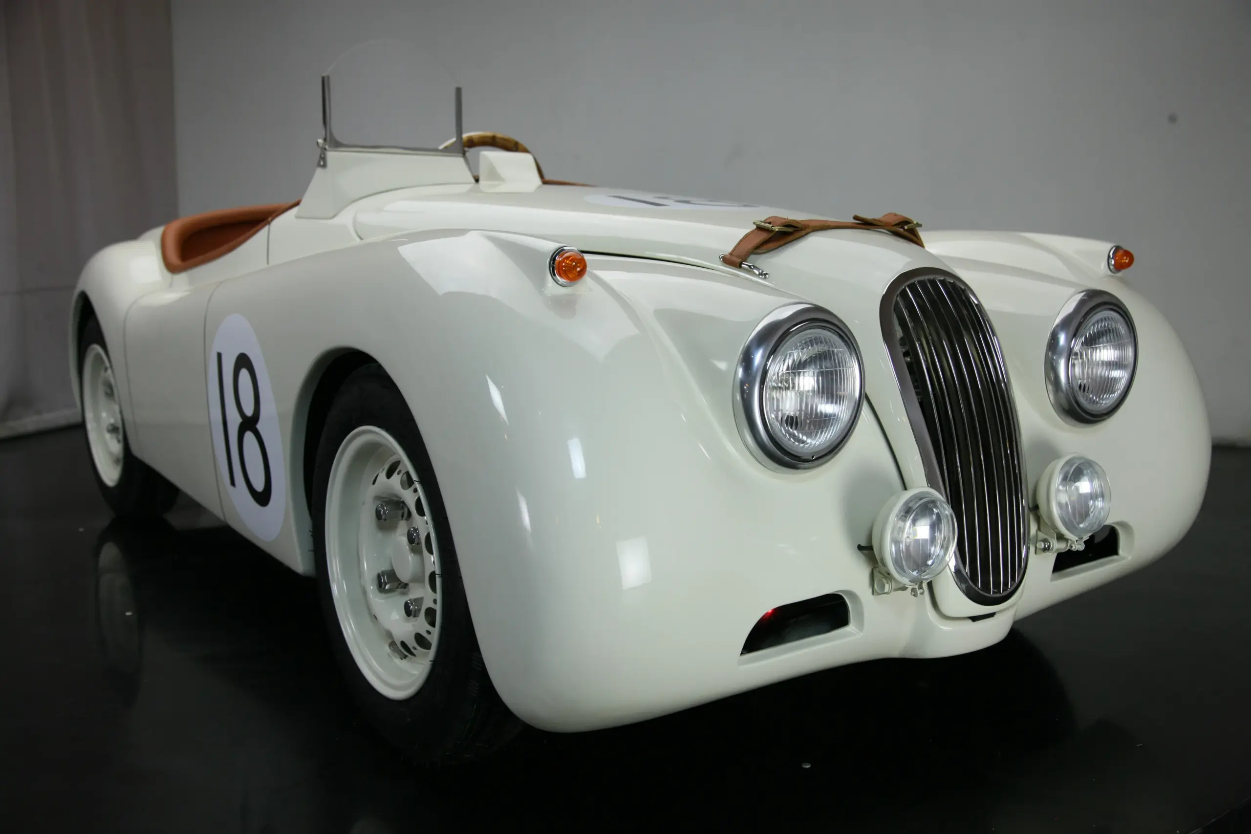 Weiße handgefertigte Replik des Jaguar XK120 Roadster mit Startnummer 18 und klassischen Rundscheinwerfern.