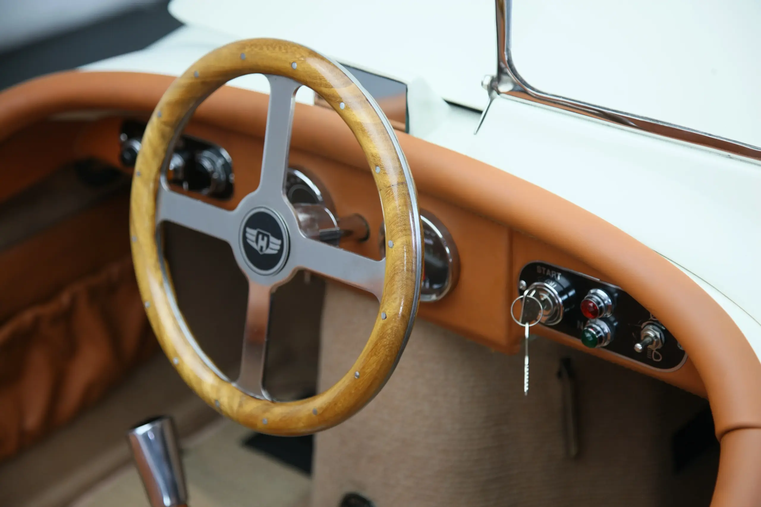 Detaillierte Aufnahme des klassischen Cockpits des XK120 Roadster Red mit Holz-Aluminium-Lenkrad und Lederarmaturen.