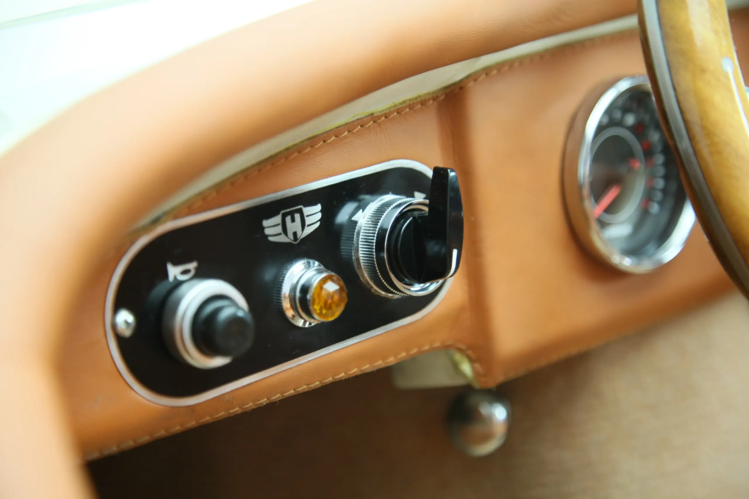 Armaturenbrett mit klassischem Schalter, Kontrollleuchte und Tachometer im XK120 Roadster Red