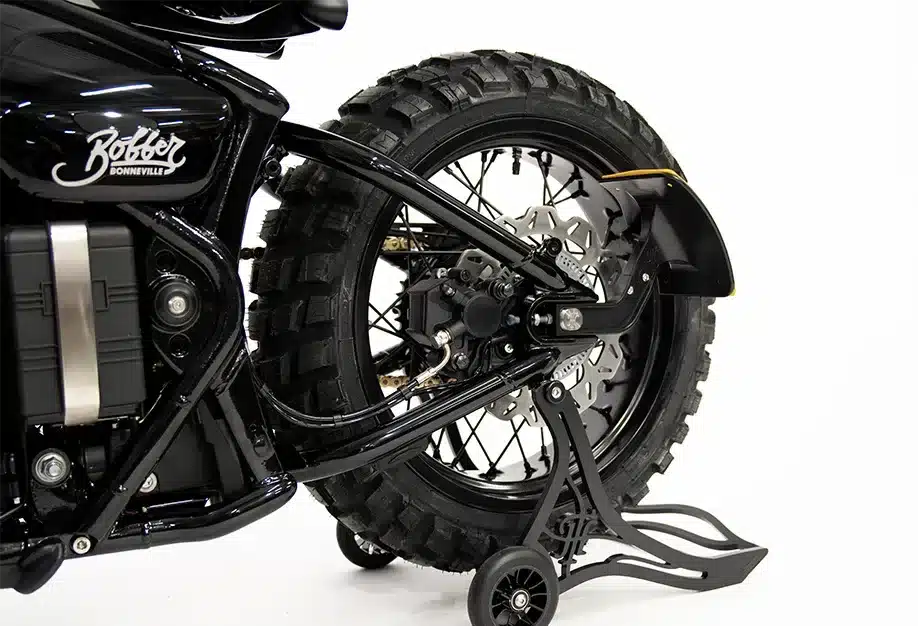 Breites Speichen-Hinterrad mit Stollenreifen an einer Thornton Hundred Adventure Bobber, Fokus auf Bereifung und Felge.