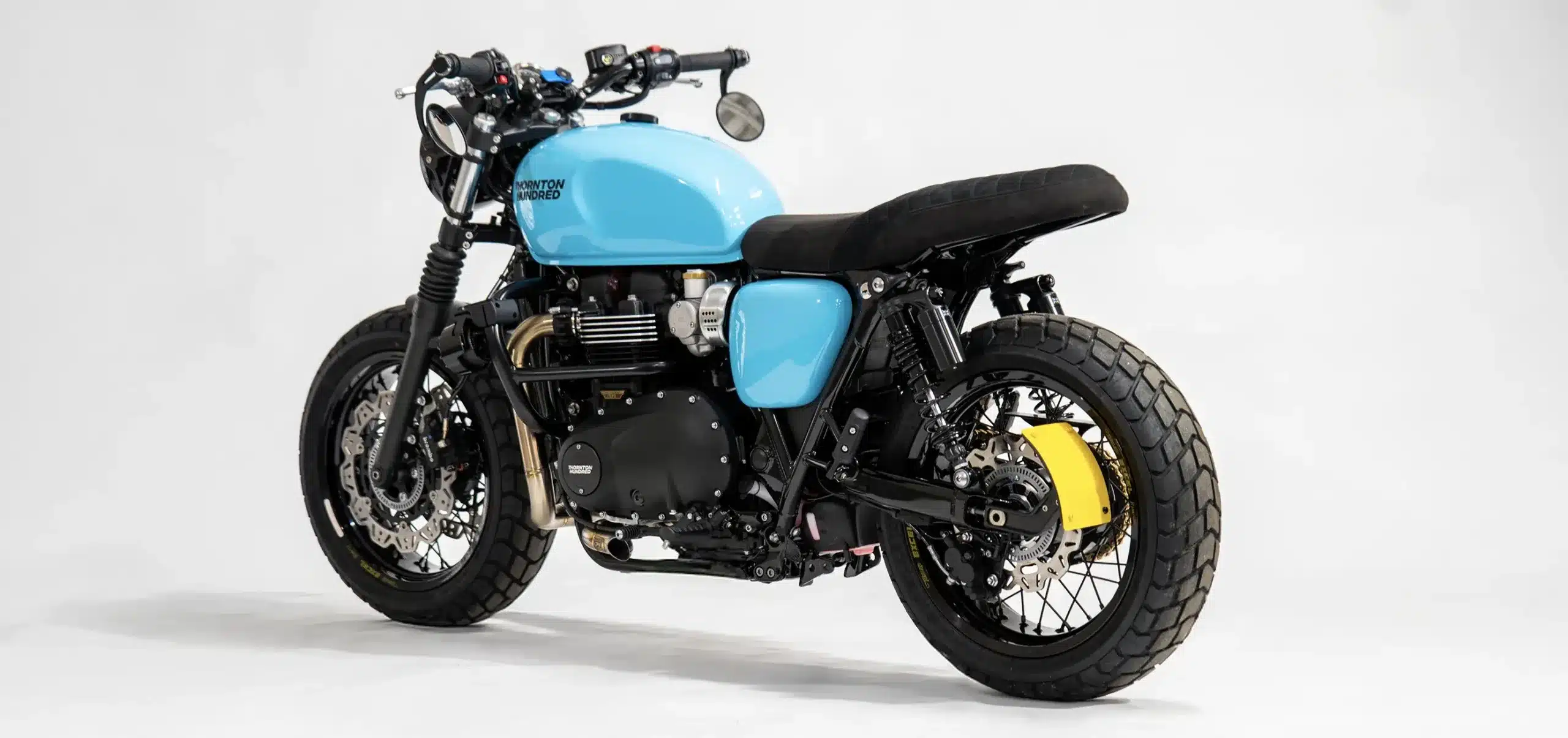 Custom Triumph Bonneville T120 von Thornton Hundred mit blauem Tank und breiten Speichenrädern