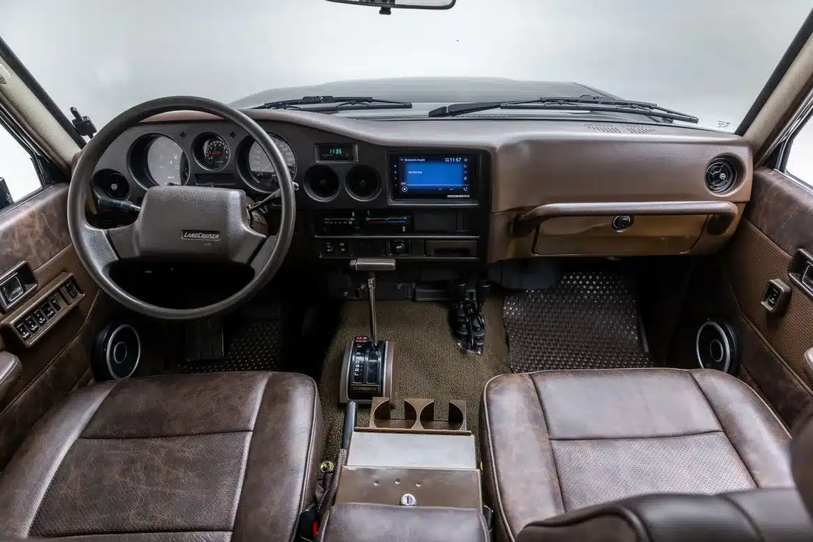 Cockpit des Toyota Land Cruiser FJ62 The Hulk mit braunem Leder, Automatik-Wählhebel und integriertem Touchscreen.