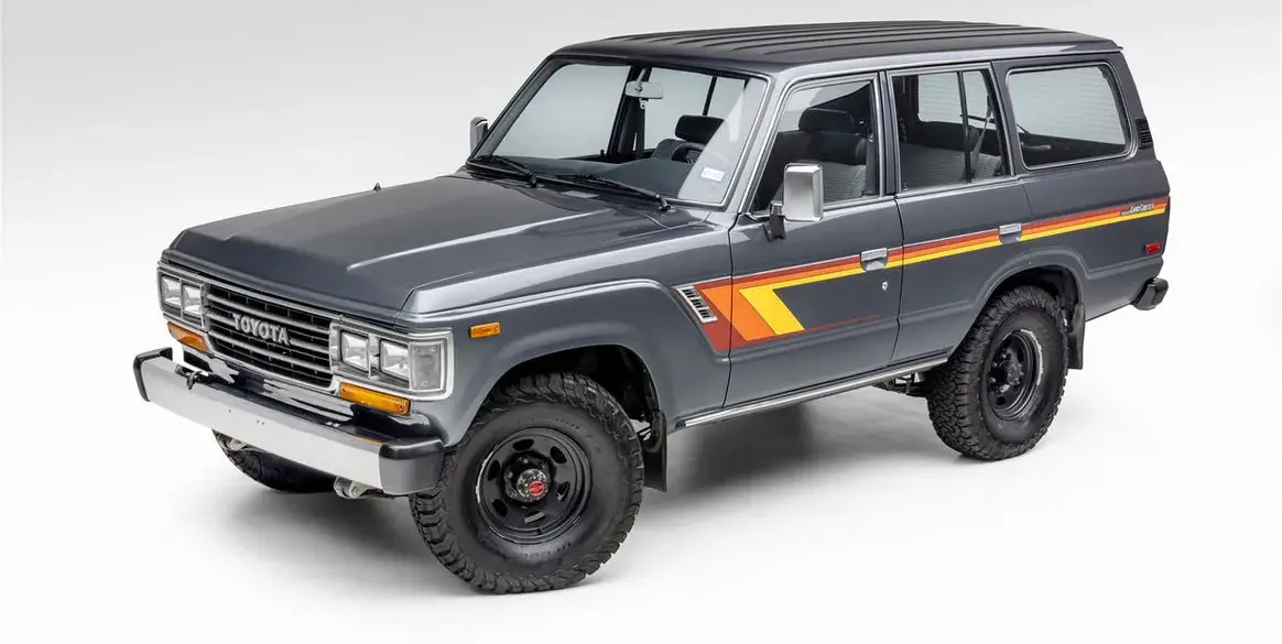 Restaurierter Toyota Land Cruiser FJ62 aus 1988 in Grau mit klassischen Streifen, Seitenansicht vor neutralem Hintergrund