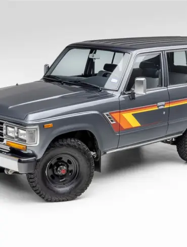 Restaurierter Toyota Land Cruiser FJ62 aus 1988 in Grau mit klassischen Streifen, Seitenansicht vor neutralem Hintergrund
