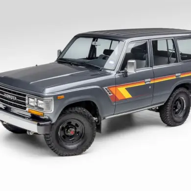 Restaurierter Toyota Land Cruiser FJ62 aus 1988 in Grau mit klassischen Streifen, Seitenansicht vor neutralem Hintergrund