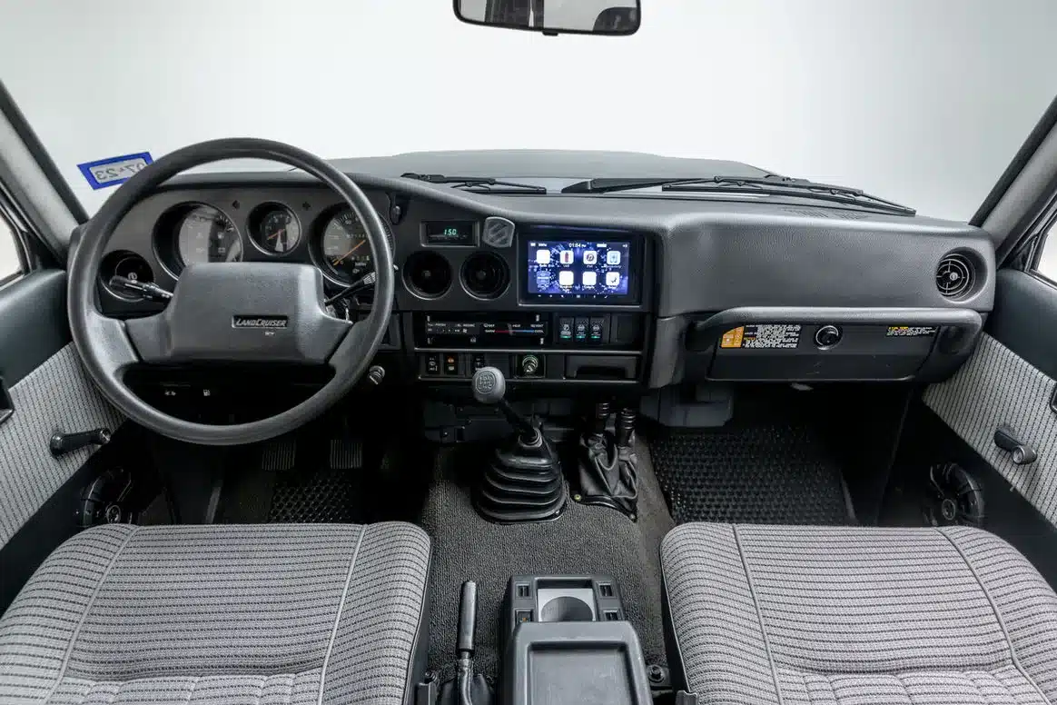 Innenraum und Armaturenbrett eines restaurierten Toyota Land Cruiser FJ62 mit neuem Audiosystem.