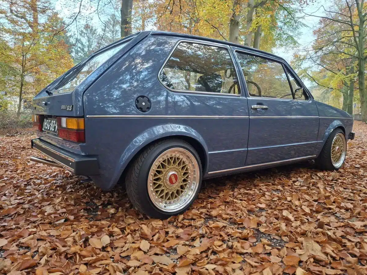Heckansicht eines restaurierten Volkswagen Golf I GLS von 1981 auf herbstlich bedecktem Waldboden