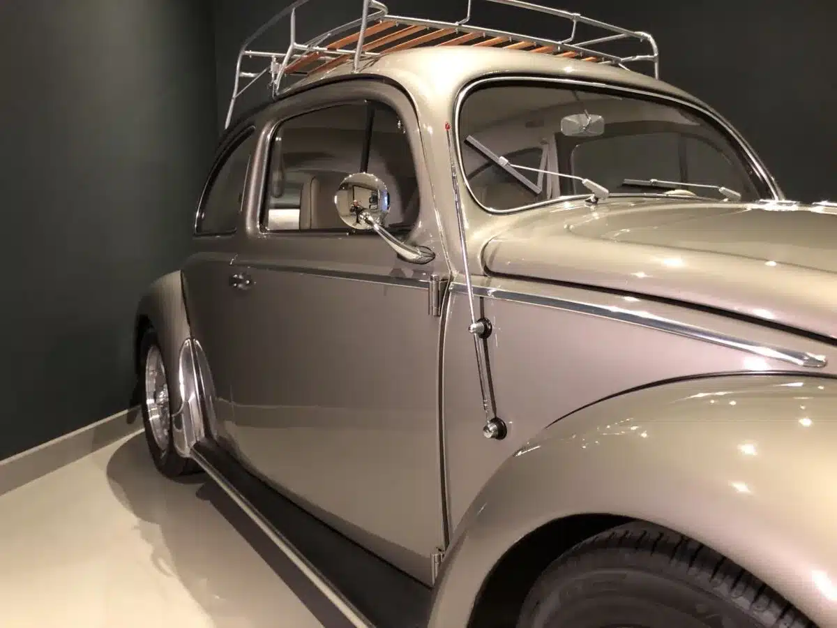 Seitenansicht eines restaurierten Volkswagen Käfer Ovalfenster von 1956 in silberner Lackierung mit Dachgepäckträger