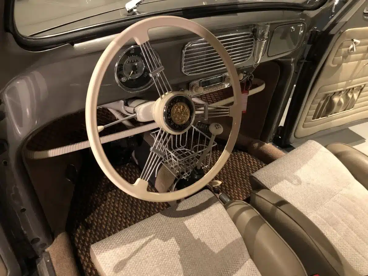 Blick auf das Armaturenbrett, Lenkrad und Vordersitze eines Volkswagen Käfer Ovalfenster Baujahr 1956 nach Restaurierung